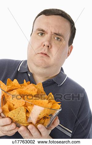 Mid-adult man holding glass bowl of potato chips View Large Photo Image Stock Image - Mid-adult man holding glass bowl of potato chips. Fotosearch