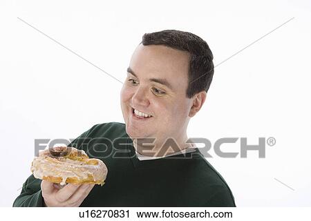 Mid-adult man holding pastry View Large Photo Image Stock Image - Mid-adult man holding pastry. Fotosearch