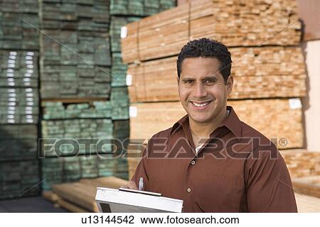 Mid-adult man stock-taking in warehouse View Large Photo Image Stock Image - Mid-adult man stock-taking in warehouse. Fotosearch