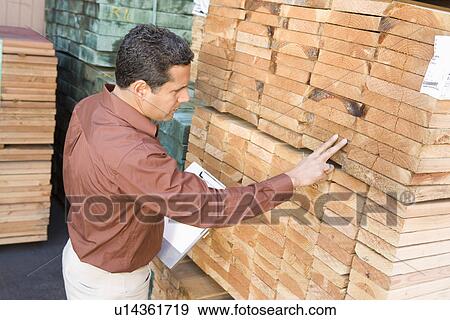 Stock Photo - Mid-adult man stock-taking in warehouse. Fotosearch