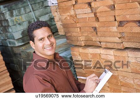 Stock Photography - Mid-adult man stock-taking in warehouse. Fotosearch