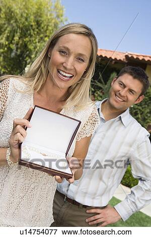 Stock Photo - Mid-adult showing pearl necklace, excited. Fotosearch