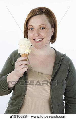 Mid-adult woman holding ice cream cone, portrait View Large Photo Image Picture - Mid-adult woman holding ice cream cone, portrait. Fotosearch