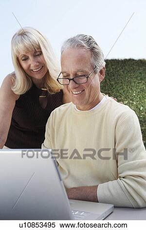 Middle aged couple Using Laptop in Garden View Large Photo Image Stock Photography - Middle aged couple Using Laptop in Garden. Fotosearch