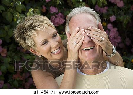 Stock Image - Middle-aged having fun in garden. Fotosearch