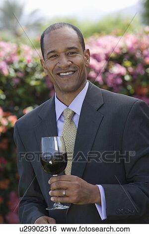 Stock Photograph - Middle-aged man with red wine. Fotosearch