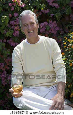 Middle-aged man with wine in garden View Large Photo Image Stock Image - Middle-aged man with wine in garden. Fotosearch