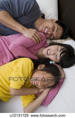Mother, father and daughter lying down on bed with eyes closed View Large Photo Image Stock Photo - Mother, father and daughter lying down on bed with eyes closed. Fotosearch