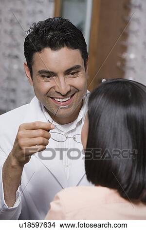 Picture - Optician helping customer. Fotosearch