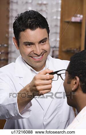 Stock Photo - Optician helping customer. Fotosearch