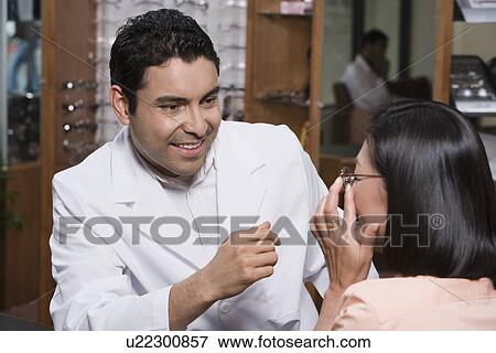 Stock Photo - Optician helping customer. Fotosearch