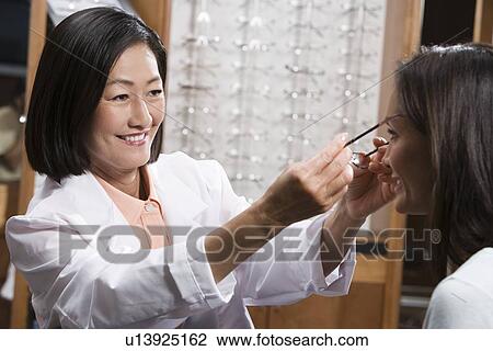 Optician with customer in store View Large Photo Image Stock Image - Optician with customer in store. Fotosearch