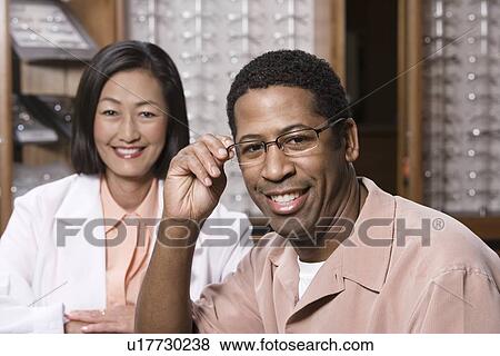 Optician with customer in store View Large Photo Image Stock Photo - Optician with customer in store. Fotosearch