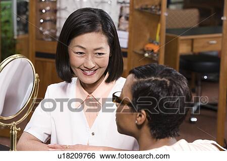 Optician with customer in store View Large Photo Image Stock Photograph - Optician with customer in store. Fotosearch
