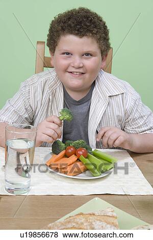 Stock Photo - Overweight boy having healthy meal.. Fotosearch
