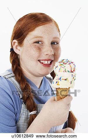 Stock Photo - Overweight girl (13-15) smiling, holding ice cream cone, portrait. Fotosearch