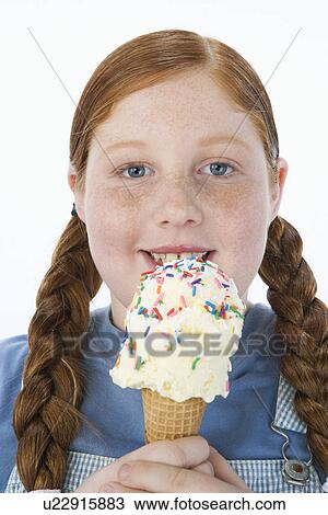 Stock Image - Overweight girl holding ice cream cone, portrait. Fotosearch