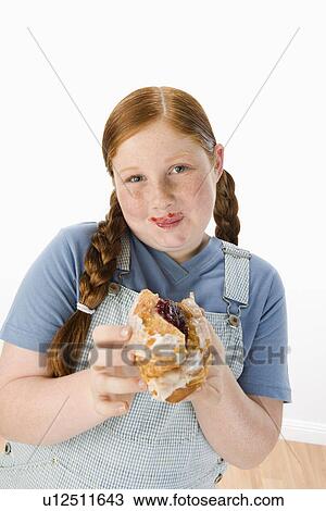 Overweight girl holding pastry, portrait View Large Photo Image Stock Image - Overweight girl holding pastry, portrait. Fotosearch