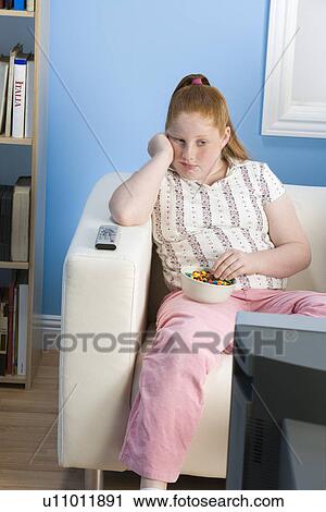 Overweight girl watching television on sofa View Large Photo Image Stock Image - Overweight girl watching television on sofa. Fotosearch