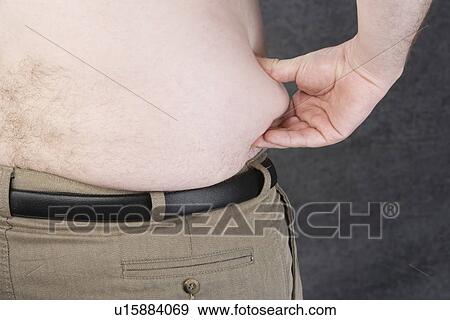 Overweight man pinching his Love Handles View Large Photo Image Stock Photo - Overweight man pinching his Love Handles. Fotosearch