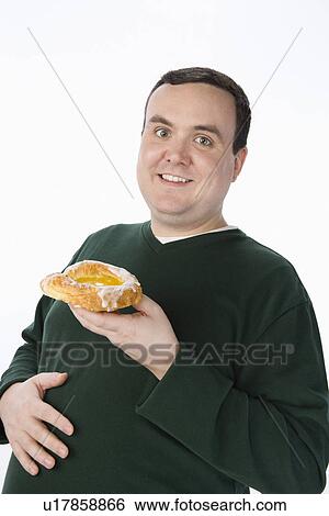 Overweight mid-adult man holding pastry View Large Photo Image Stock Photograph - Overweight mid-adult man holding pastry. Fotosearch