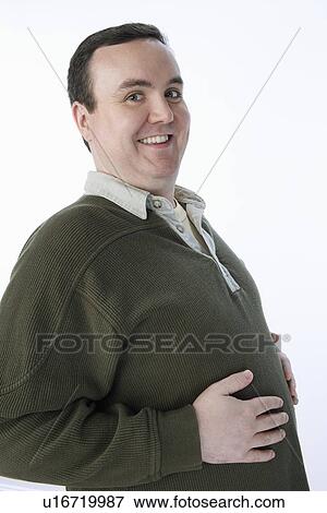 Overweight mid-adult man with hands on his belly View Large Photo Image Stock Photo - Overweight mid-adult man with hands on his belly. Fotosearch
