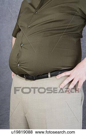 Stock Photo - Overweight mid-adult man with hands on hips, mid section. Fotosearch