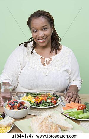 Stock Photo - Overweight mid-adult woman having healthy meal. Fotosearch
