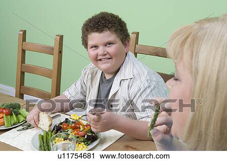Overweight mother with overweight son having healthy meal View Large Photo Image Stock Image - Overweight mother with overweight son having healthy meal. Fotosearch