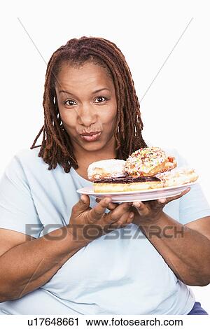 Stock Image - Overweight Woman holding Junk Food, portrait. Fotosearch