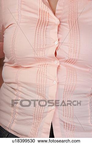 Stock Image - Overweight Woman in tight blouse, mid section, front view. Fotosearch