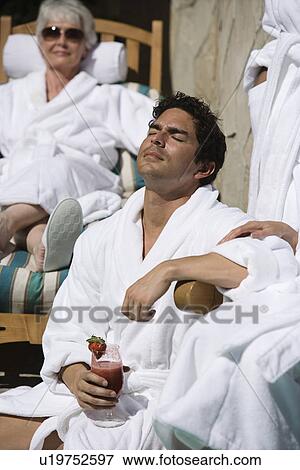 Stock Photo - People in bathrobes, relaxing outdoors. Fotosearch