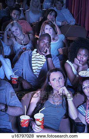 People sitting, leaning on arms, Watching Boring Movie View Large Photo Image Stock Photo - People sitting, leaning on arms, Watching Boring Movie. Fotosearch
