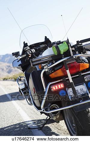 Police motorcycle standing on side of desert road, rear view View Large Photo Image Picture - Police motorcycle standing on side of desert road, rear view. Fotosearch