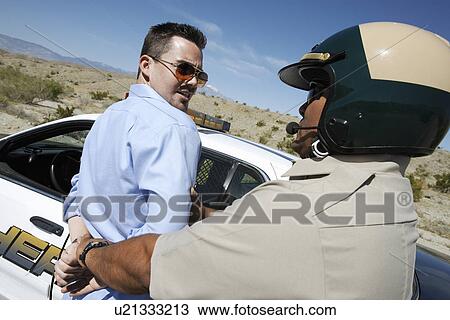 Police officer assisting arrested man into police car View Large Photo Image Stock Image - Police officer assisting arrested man into police car. Fotosearch