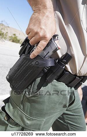 Police officer drawing gun from holster, mid section, (mid section) View Large Photo Image Stock Photo - Police officer drawing gun from holster, mid section, (mid section). Fotosearch