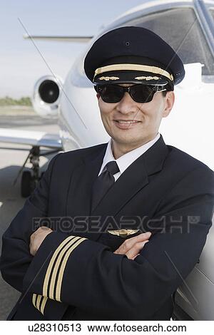 Portrait of Asian male pilot in front of private jet. View Large Photo Image Stock Image - Portrait of Asian male pilot in front of private jet.. Fotosearch