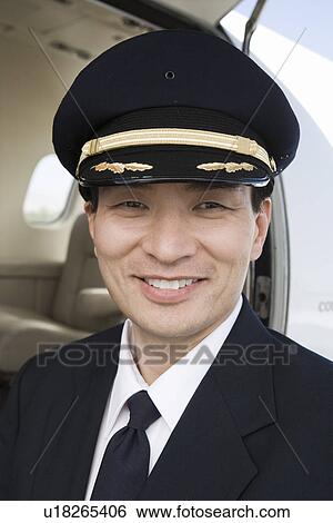 Portrait of Asian male pilot in front of private jet. View Large Photo Image Stock Photograph - Portrait of Asian male pilot in front of private jet.. Fotosearch