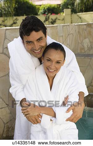 Stock Photo - Portrait of couple in bathrobes, outdoors. Fotosearch