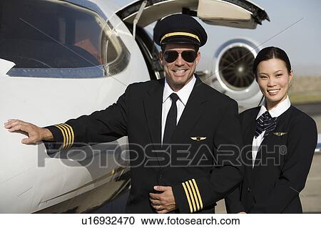 Portrait of mid-adult airline pilot and flight attendant in front of airplane. View Large Photo Image Stock Image - Portrait of mid-adult airline pilot and flight attendant in front of airplane.. Fotosearch