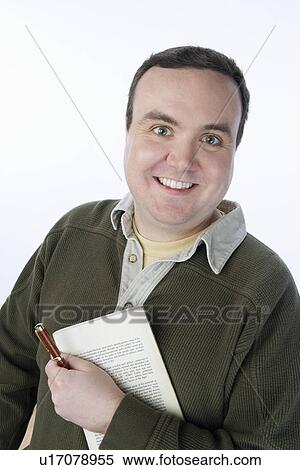Stock Photography - Portrait of mid-adult man holding pen and book. Fotosearch