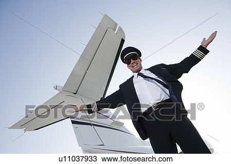 Portrait of pilot standing in front of airplane. View Large Photo Image Stock Image - Portrait of pilot standing in front of airplane.. Fotosearch