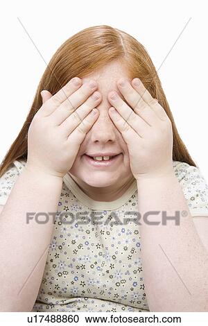 Stock Image - Portrait of teenage girl covering eyes with hands. Fotosearch