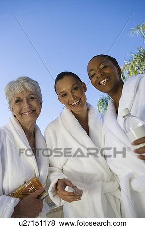 Stock Photo - Portrait of three women in bathrobes at health spa. Fotosearch