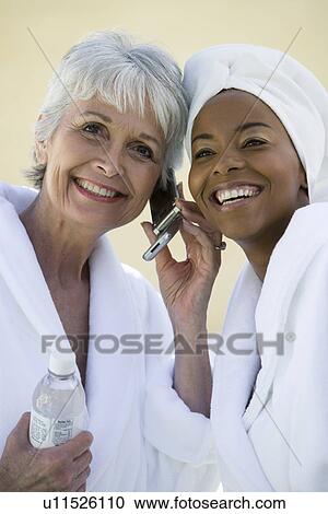 Portrait of two women in bathrobes using mobile phone View Large Photo Image Stock Image - Portrait of two women in bathrobes using mobile phone. Fotosearch
