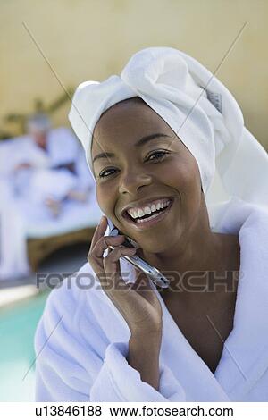 Stock Photo - Portrait of woman in bathrobe using mobile phone. Fotosearch