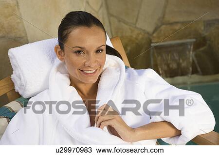 Stock Image - Portrait of woman relaxing by pool. Fotosearch