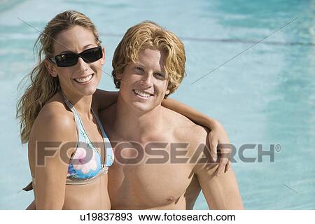 Stock Image - Portrait of Young Couple in Pool. Fotosearch
