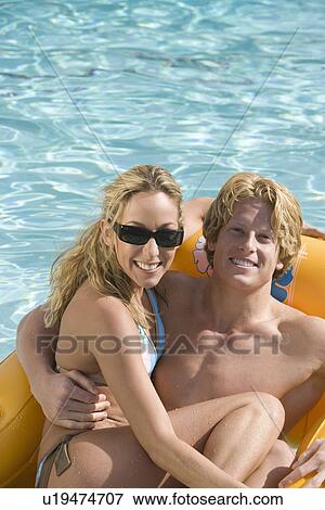 Portrait of Young Couple on Inflatable Raft in Pool View Large Photo Image Stock Photo - Portrait of Young Couple on Inflatable Raft in Pool. Fotosearch