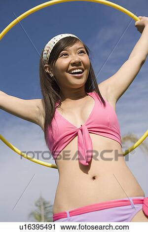 Stock Image - Portrait of Young Woman with Hula Hoop, Smiling. Fotosearch